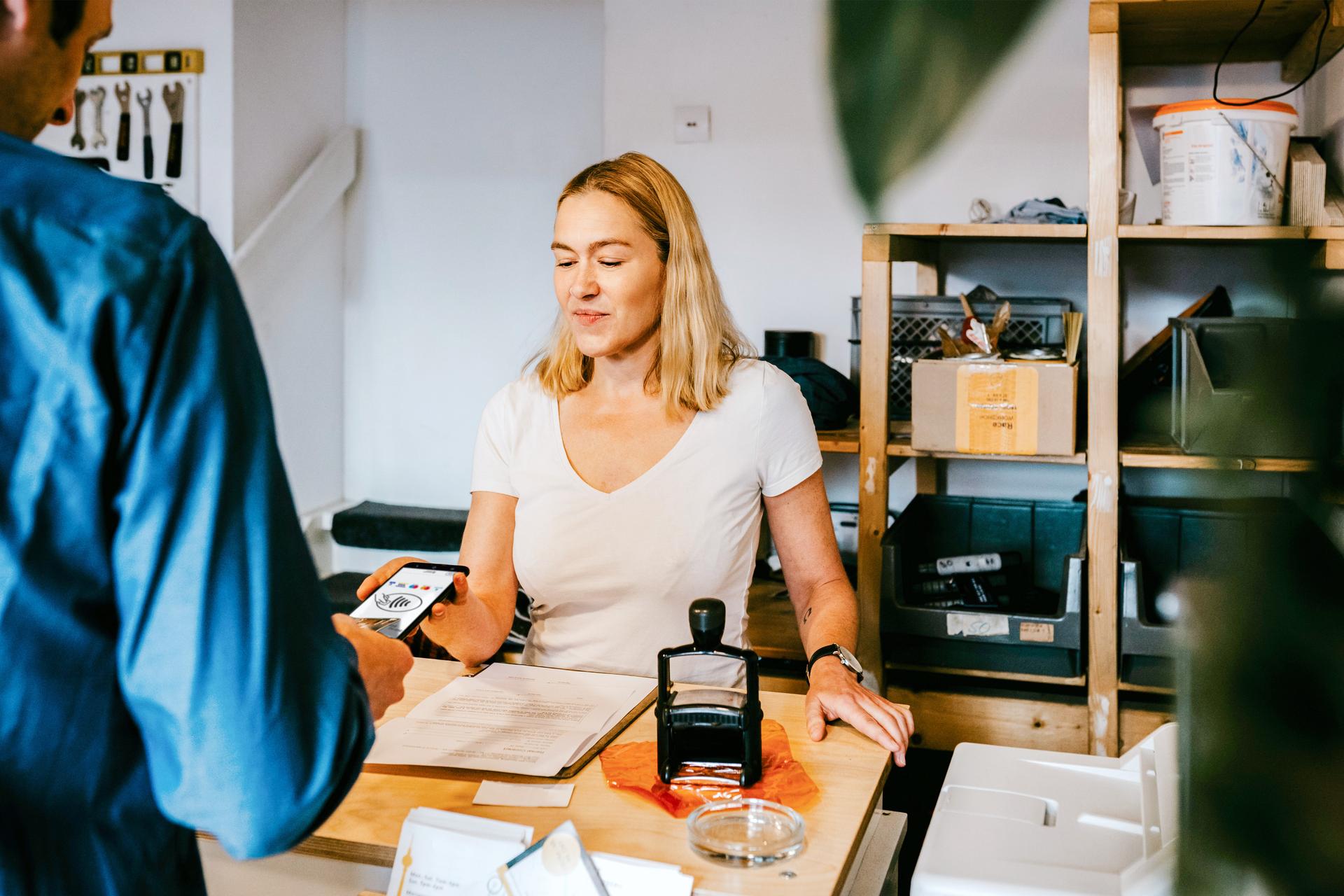 Ein Bezahlvorgang mit der S-POS App. Es sind eine Frau und ein Mann zu sehen.