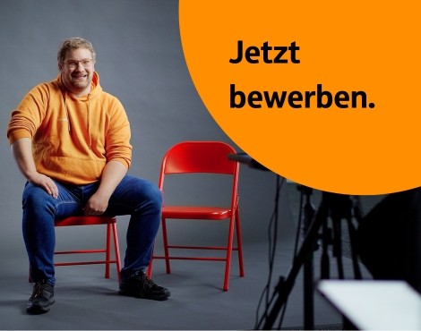 Karriereseite Mitarbeitende mit Teamspirit wird von mehreren jubelnden Personen ausgestrahlt; schwarz-weiß mit orangenem Gestaltungselement links
