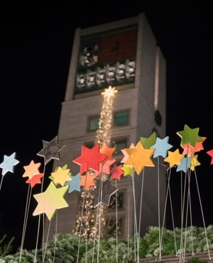 Bunte Sterne vor Nachthimmel auf dem Weihnachtsmarkt , Stuttgarter Rathaus im Hintergrund