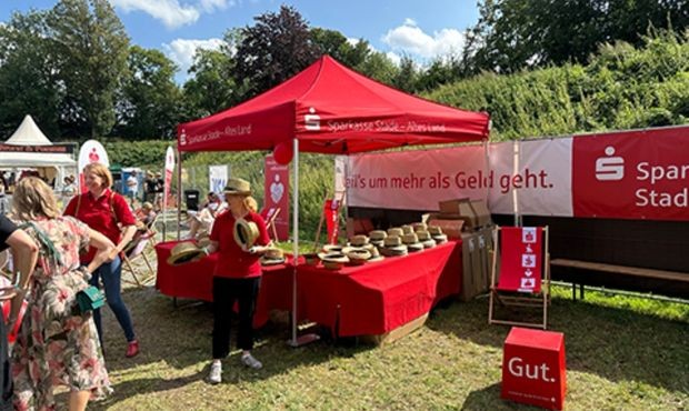roter Sparkassenstand auf einer Wiese beim Festival