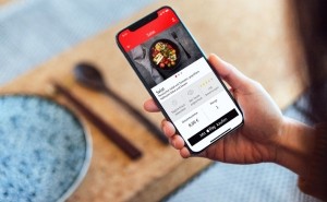 Smartphone in der Hand mit einer Essensbestellung auf dem Display im Bezahlvorgang mit Apple-Pay und girocard