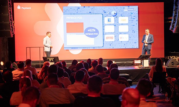 2 Männer stehen auf einer Bühne vor Publikum und halten einen Vortrag. Es sind André Pallinger, CEO von S-Markt und Mehrwert und Florian Wolfframm, Geschäftsleitung Retail Sales & Marketing bei PAYBACK Payment-Symposium 2025 Rückblick